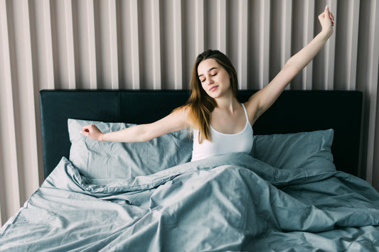 Woman on bed stretching after a quick nap